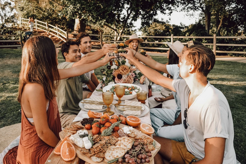 Evento en un jardín  con unos amigos brindando en una casa rural